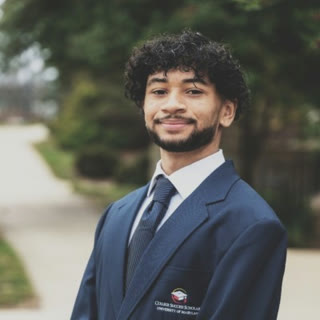 Jayden Williams in a navy blazer and tie, smiling, outdoors